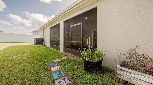 view of yard featuring central AC unit, fence, and a sunroom