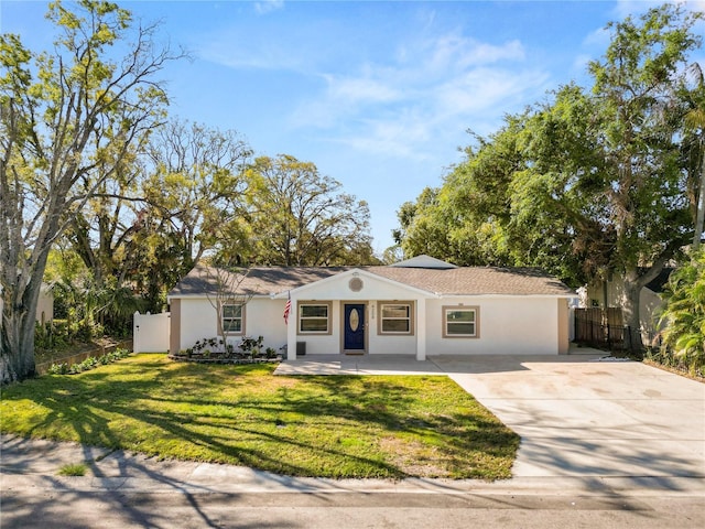 ranch-style home with stucco siding, driveway, a front lawn, and fence