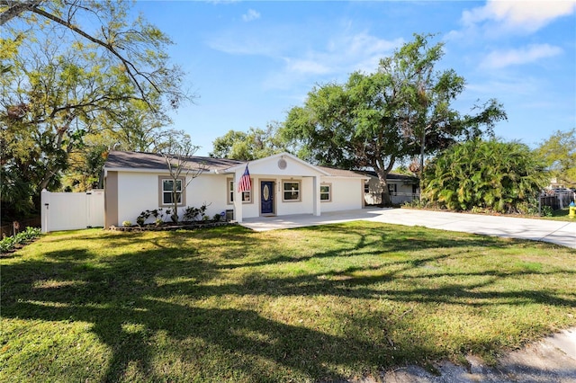 view of front of property featuring stucco siding, driveway, a front yard, and fence