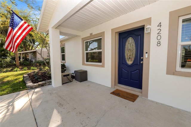 view of exterior entry featuring stucco siding