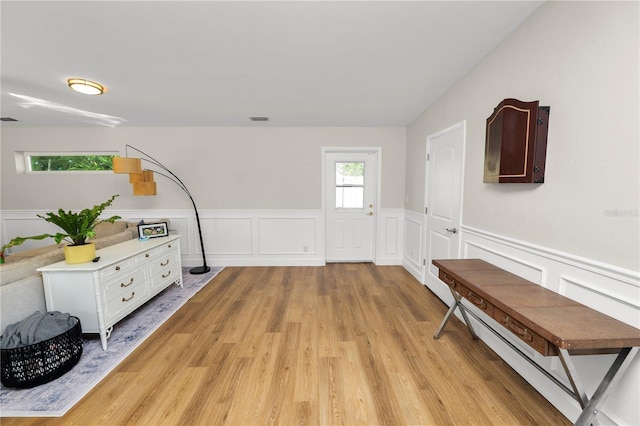 entryway with light wood finished floors, visible vents, a baseboard heating unit, and a wainscoted wall