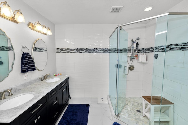 full bathroom with visible vents, a stall shower, and a sink