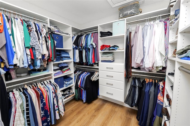 spacious closet with light wood-style flooring and attic access