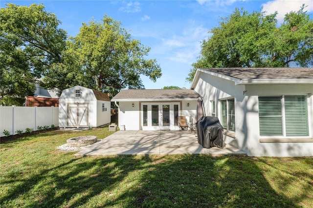 back of house featuring fence, a shed, an outdoor structure, french doors, and a patio area