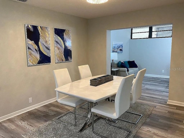 dining area with baseboards and wood finished floors