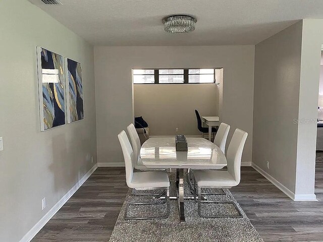 dining room with visible vents, baseboards, and dark wood-style flooring