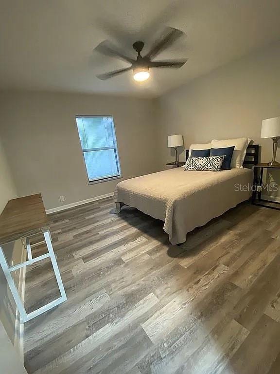 bedroom with ceiling fan and wood finished floors