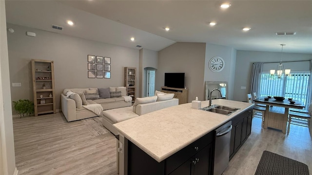 kitchen featuring a chandelier, dishwasher, lofted ceiling, arched walkways, and a sink