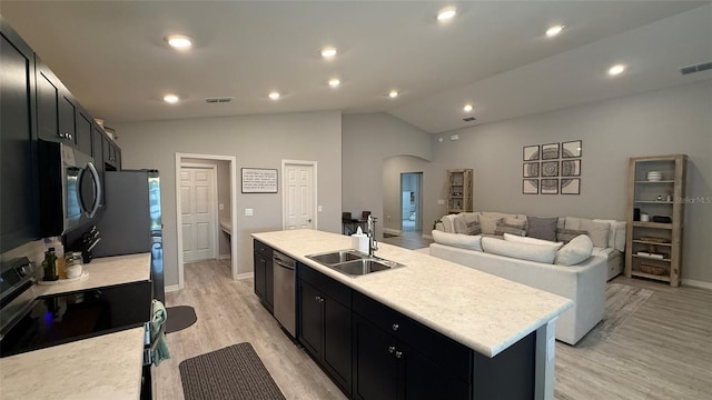 kitchen featuring arched walkways, visible vents, appliances with stainless steel finishes, and a sink