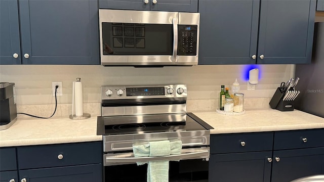 kitchen featuring light countertops, blue cabinets, and appliances with stainless steel finishes