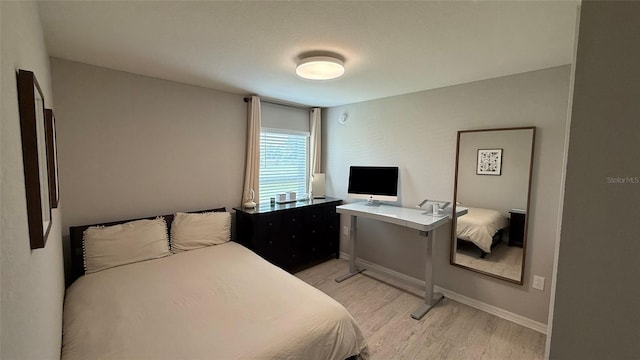 bedroom featuring baseboards and light wood-style floors