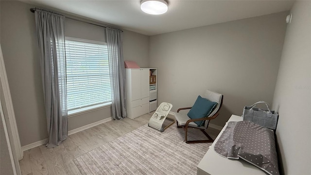 living area with baseboards and light wood finished floors