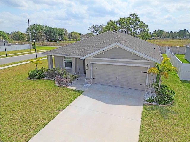 ranch-style home featuring driveway, fence, a front yard, a shingled roof, and a garage