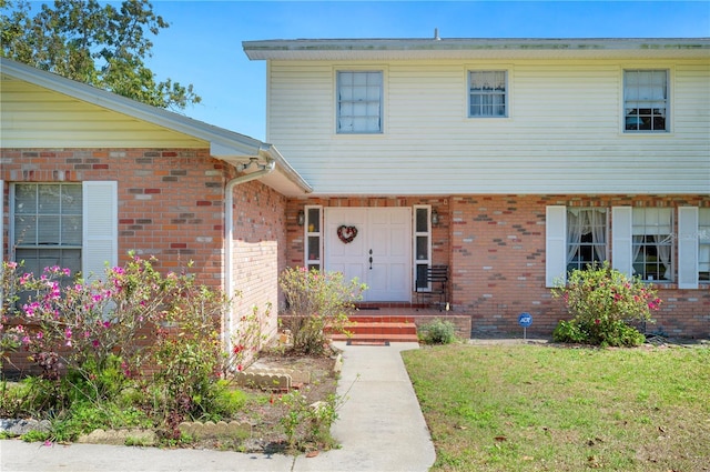 view of front of house featuring a front lawn and brick siding