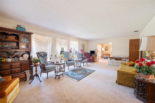 living room featuring visible vents, a textured ceiling, and carpet