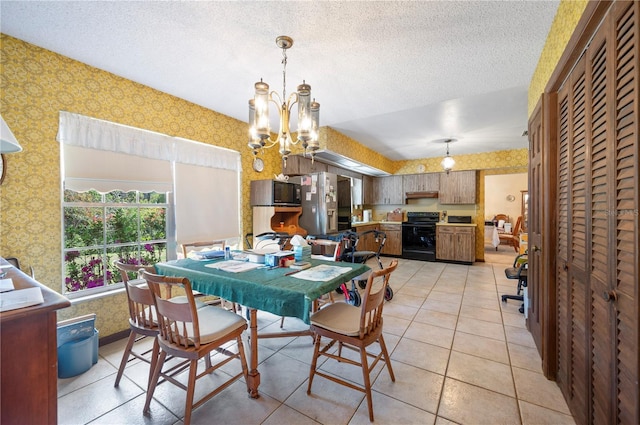 dining area featuring light tile patterned flooring, a notable chandelier, a textured ceiling, and wallpapered walls