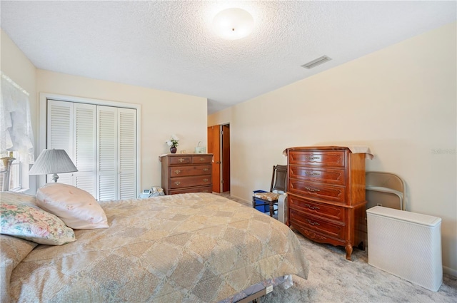 carpeted bedroom featuring visible vents and a textured ceiling