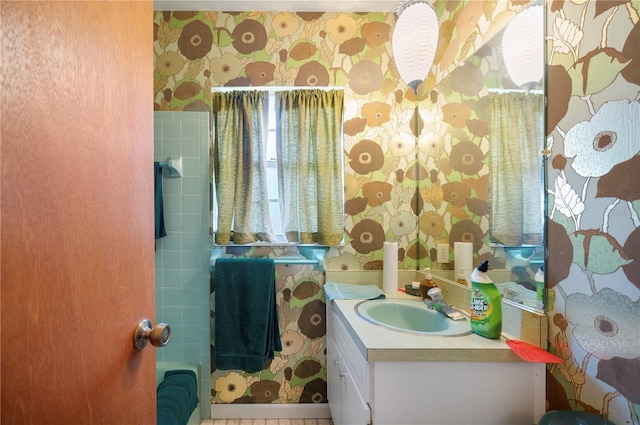 bathroom with wallpapered walls and vanity