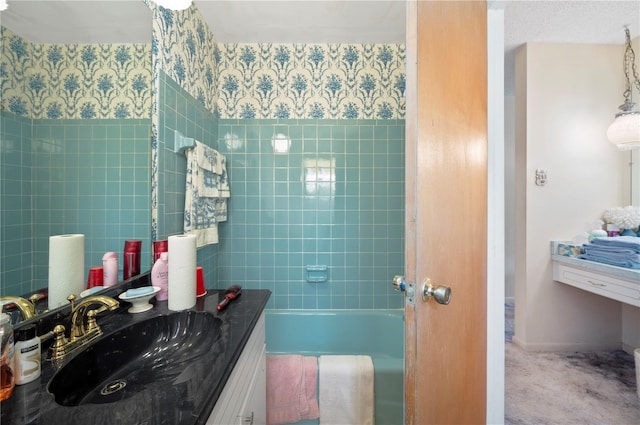 bathroom featuring a bathing tub, wallpapered walls, vanity, and baseboards