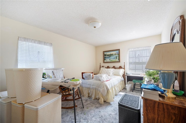 bedroom featuring light carpet and a textured ceiling