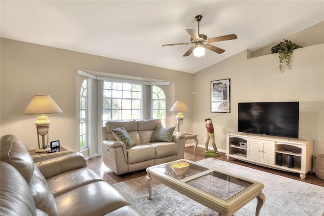 living room featuring tile patterned floors, baseboards, ceiling fan, and vaulted ceiling