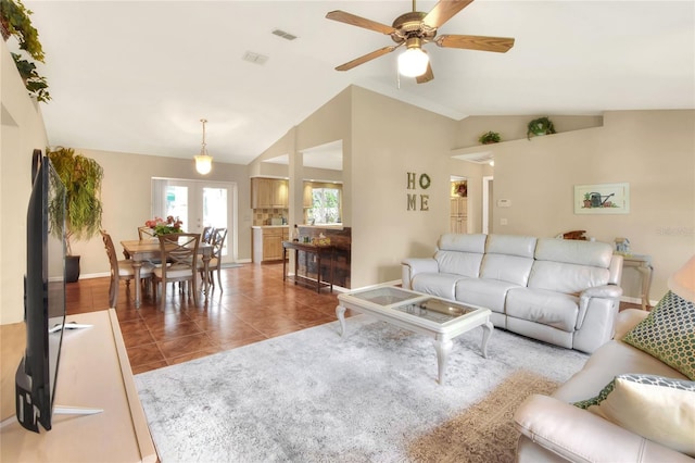 tiled living area with visible vents, lofted ceiling, baseboards, and ceiling fan