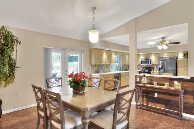 dining room featuring a ceiling fan, vaulted ceiling, french doors, and baseboards