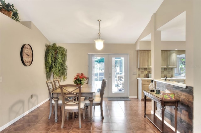 dining space with light tile patterned flooring, french doors, baseboards, and vaulted ceiling