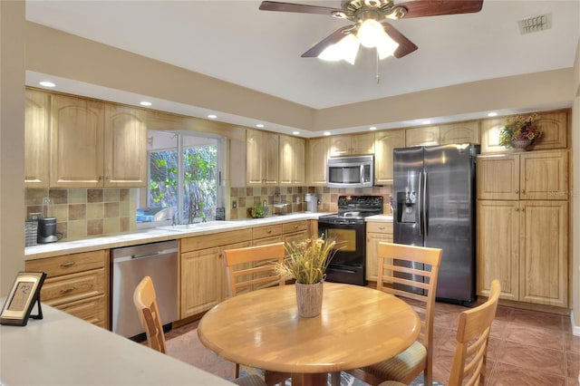 kitchen featuring visible vents, a sink, stainless steel appliances, light countertops, and tasteful backsplash