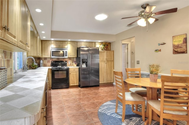 kitchen featuring a sink, recessed lighting, stainless steel appliances, decorative backsplash, and tile counters