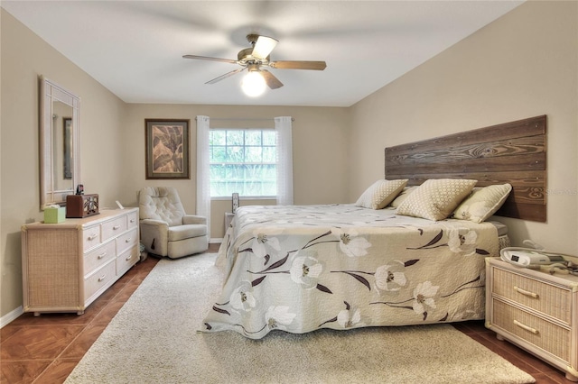 bedroom featuring ceiling fan, baseboards, and dark tile patterned floors