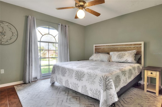 bedroom featuring multiple windows, a ceiling fan, and baseboards