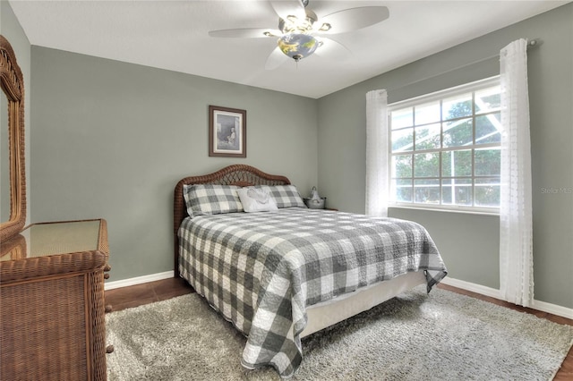 tiled bedroom featuring ceiling fan and baseboards