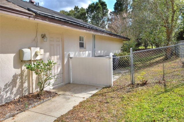 view of home's exterior with a gate, fence, roof mounted solar panels, and stucco siding