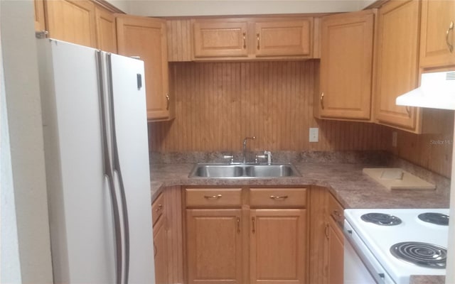 kitchen with white appliances, light brown cabinets, under cabinet range hood, and a sink