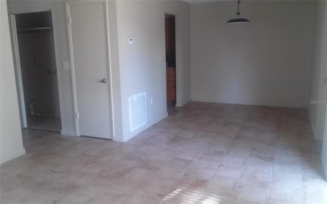 empty room featuring visible vents and baseboards