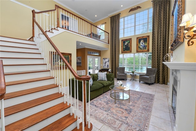 living room featuring crown molding, stairway, french doors, a towering ceiling, and tile patterned floors