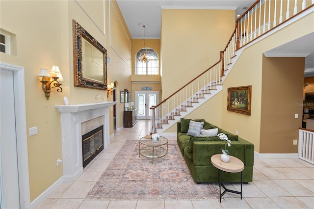 tiled living room featuring baseboards, a towering ceiling, and ornamental molding