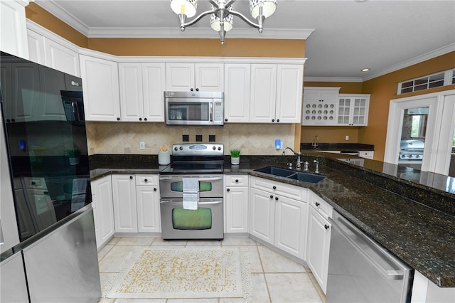 kitchen featuring a chandelier, ornamental molding, white cabinets, stainless steel appliances, and a sink