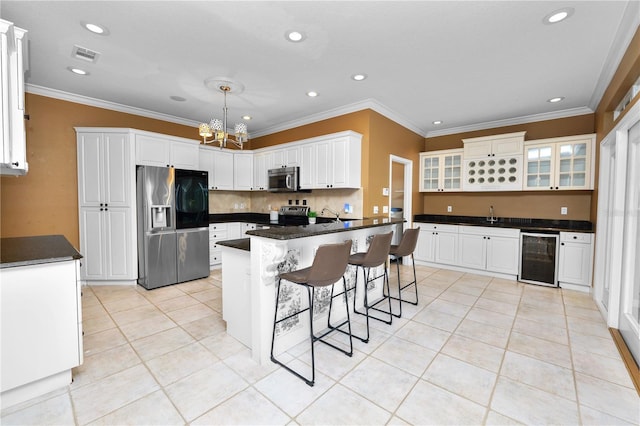 kitchen featuring dark countertops, beverage cooler, a breakfast bar area, a notable chandelier, and stainless steel appliances