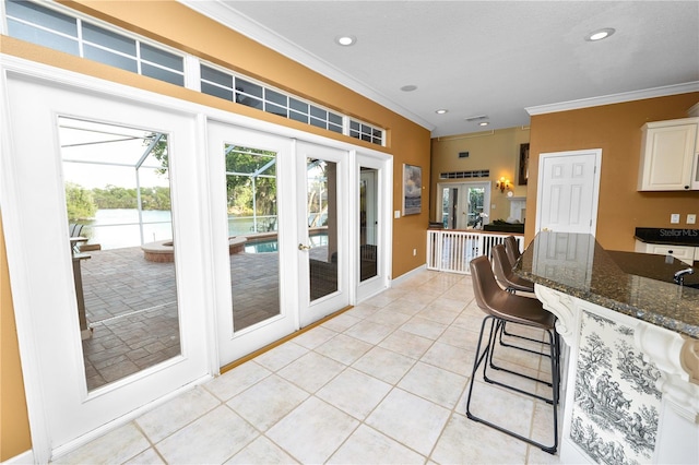 kitchen featuring light tile patterned floors, french doors, white cabinetry, and crown molding