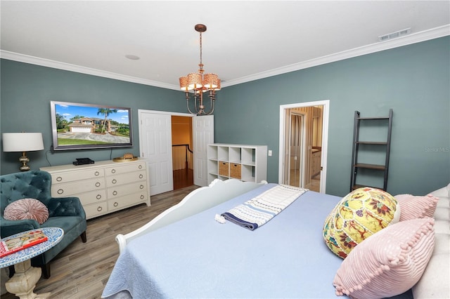 bedroom featuring visible vents, wood finished floors, a chandelier, and crown molding