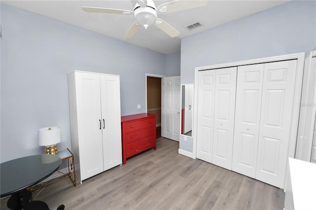 bedroom with light wood-style flooring, visible vents, and ceiling fan