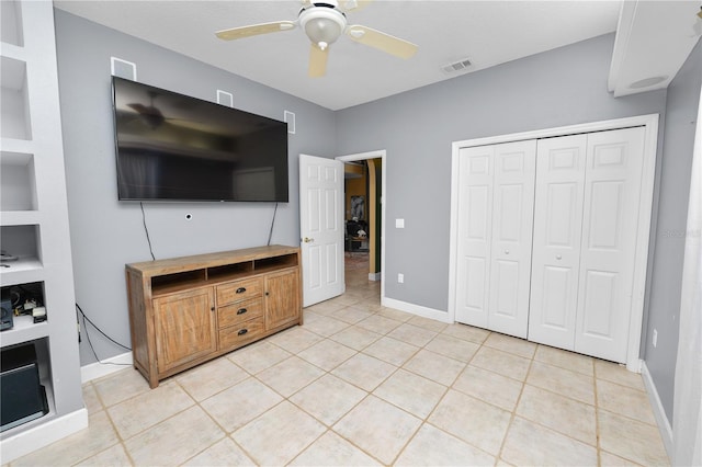 bedroom with visible vents, a closet, light tile patterned flooring, baseboards, and ceiling fan