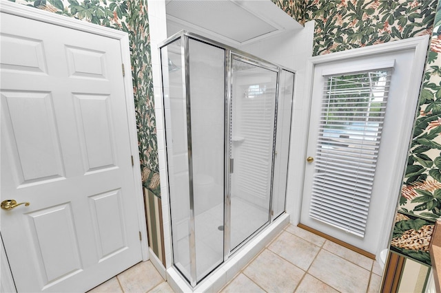 bathroom with tile patterned floors, a shower stall, and wallpapered walls