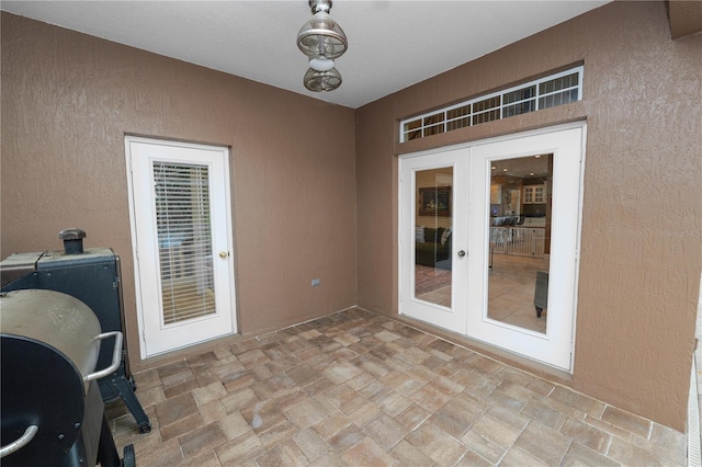 unfurnished office with french doors, stone finish flooring, and a textured wall