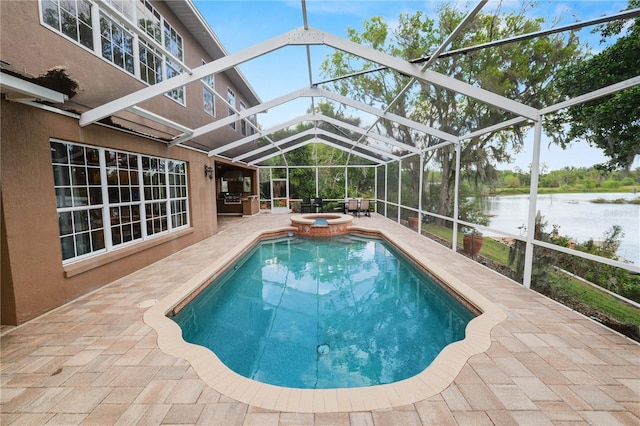 view of swimming pool with glass enclosure, a water view, a pool with connected hot tub, and a patio area