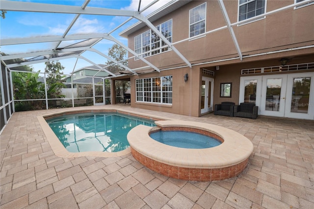 view of pool featuring french doors, a patio, glass enclosure, and a pool with connected hot tub