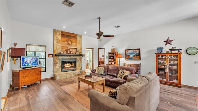 living area with visible vents, a fireplace, baseboards, and hardwood / wood-style floors