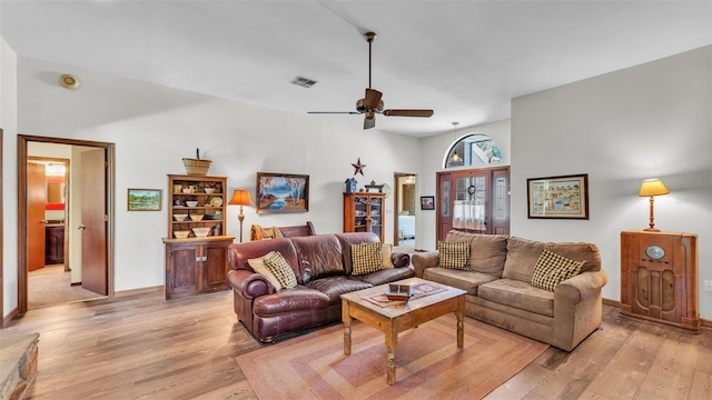 living room with visible vents, light wood-style floors, and ceiling fan